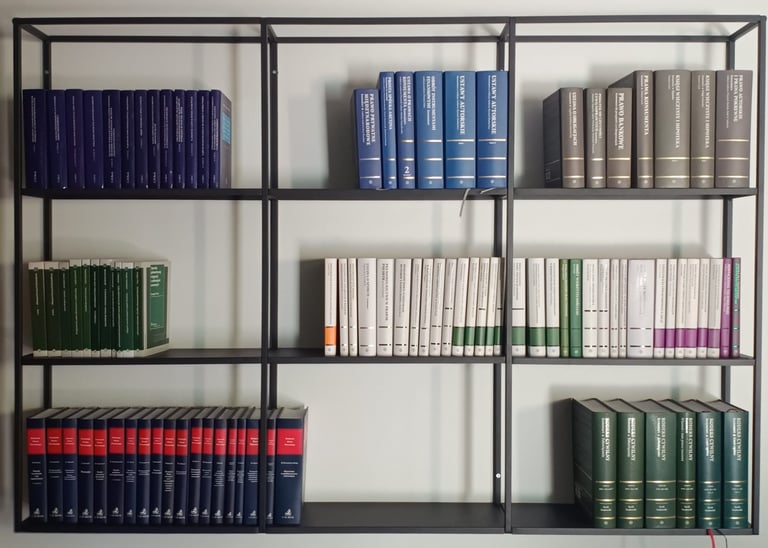 Nowoczesny, czarny regał z uporządkowanymi książkami prawniczymi o różnych kolorach okładek ustawion
