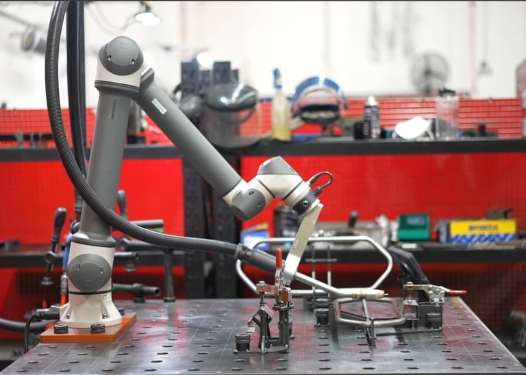 Industrial collaborative robot arm performing precise welding tasks in a modern factory setting.