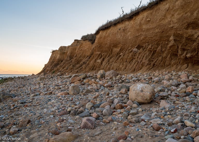 rocks and boulders with bluffs in the background in montauk point ny