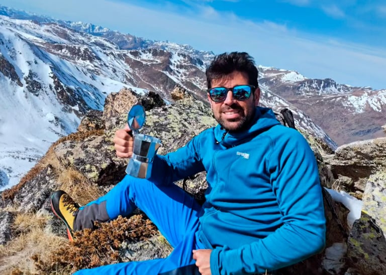 guía de montaña con una cafetera en la cima
