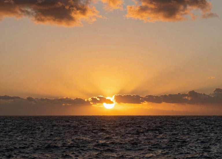 A stunning sunset over a modern luxury home overlooking the Kona coastline.