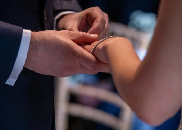 groom placing wedding ring on his bride's finger
