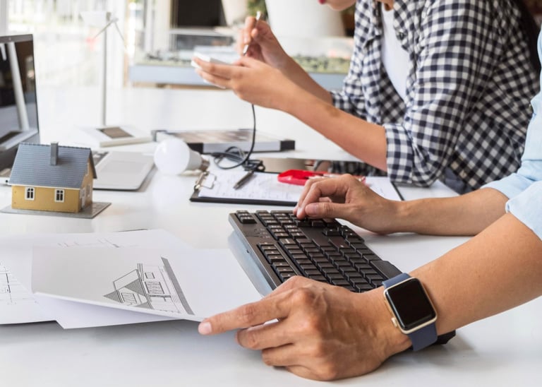 duas pessoas trabalhando bastante e observando computador, plantas tecnicas e digitando