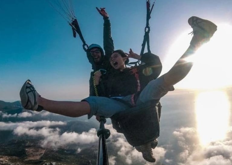 "Excited young woman soaring through the sky during a paragliding feeling the rush of adrenaline
