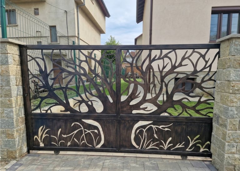 Custom decorative laser-cut metal driveway gate featuring a spreading tree design and stone pillars.