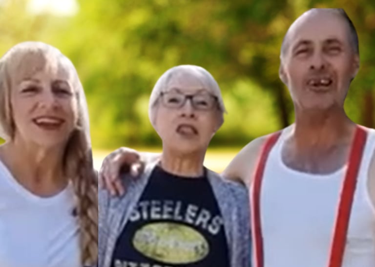 Three smiling outdoors wearing a white t-shirt, Steelers fan gear, and a tank top with red suspenders.