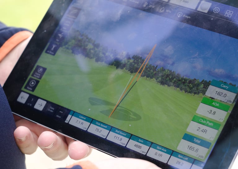 A golf coach in Aberdeen runs a gapping session using a launch monitor to help a player determine distances for each club