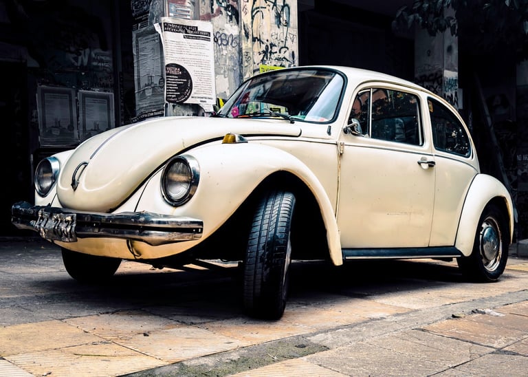a white volkswagen beetle beetle parked on a sidewalk