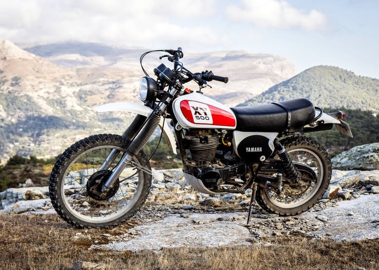 a Yamaha 500 XT parked on a rocky mountain side