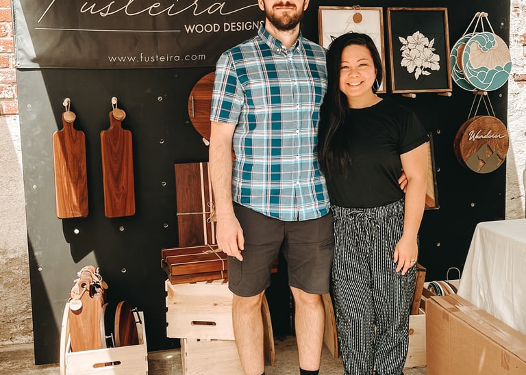 Gilliane and Victor, from Fusteira, at their booth, showcasing custom handcrafted wooden pieces.