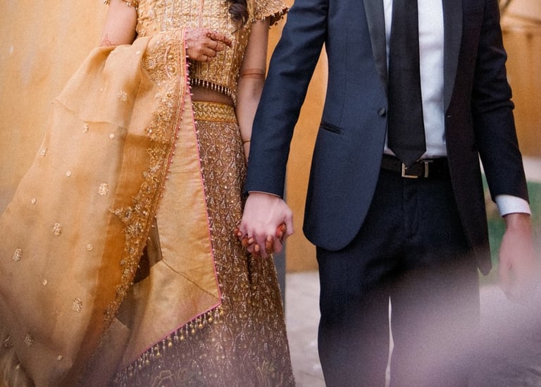 a man and woman holding hands and walking through a doorway