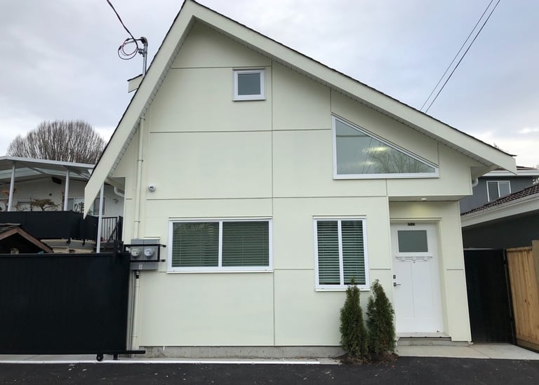 Laneway home framed within tight site access behind the main house.