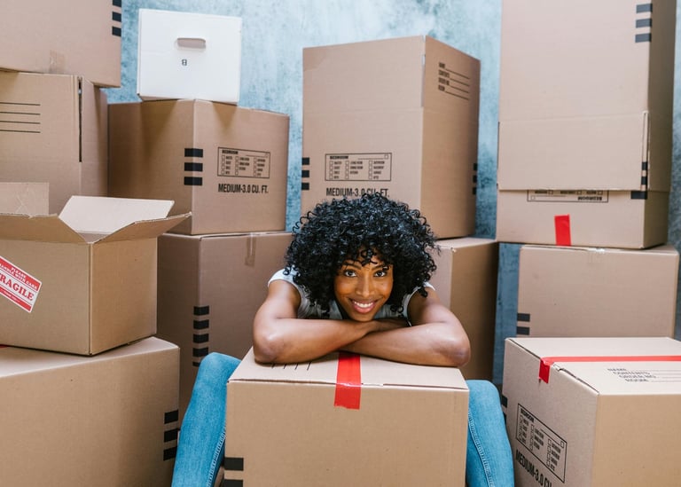 a happy woman with packed boxes for her pcs move