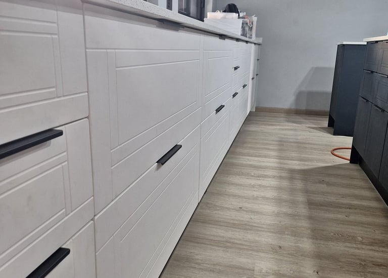 A two tone kitchen with white Thermoformed Doors, drawer panels . The handles are minimalistic 