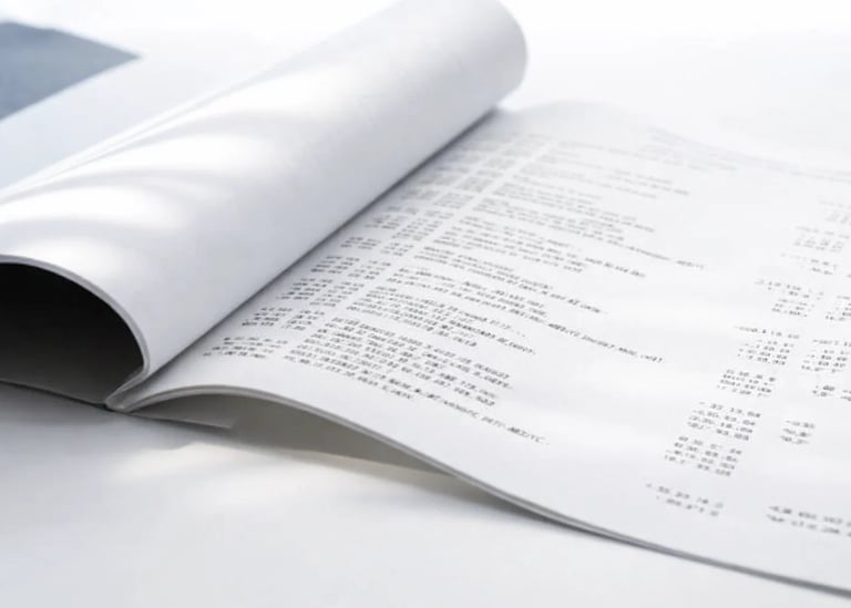Open business report document showing financial data tables and printed spreadsheet pages.
