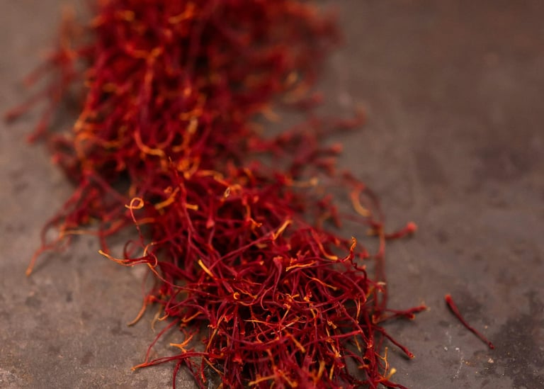 Red saffron threads spilled on a rustic surface for gourmet cooking and spice seasoning.