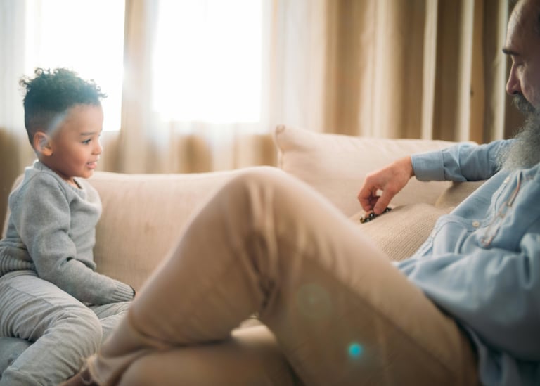a man sitting on a couch with a child