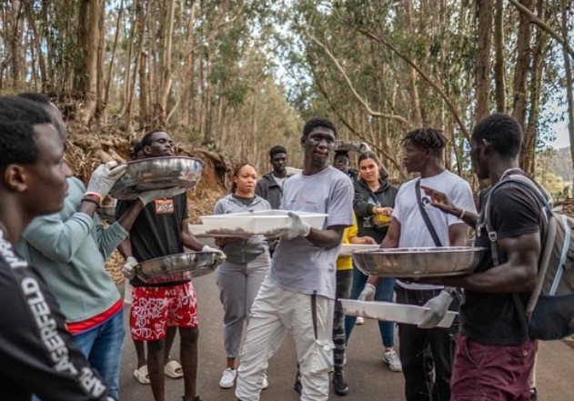 un grupo de personas afro llevando bandejas de comida