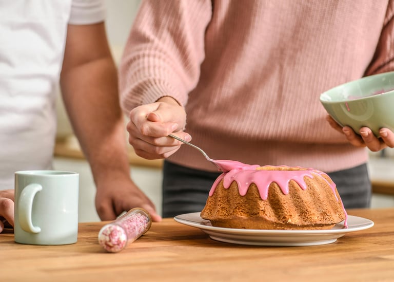 mulher colocando cobertura de morango em um bolo