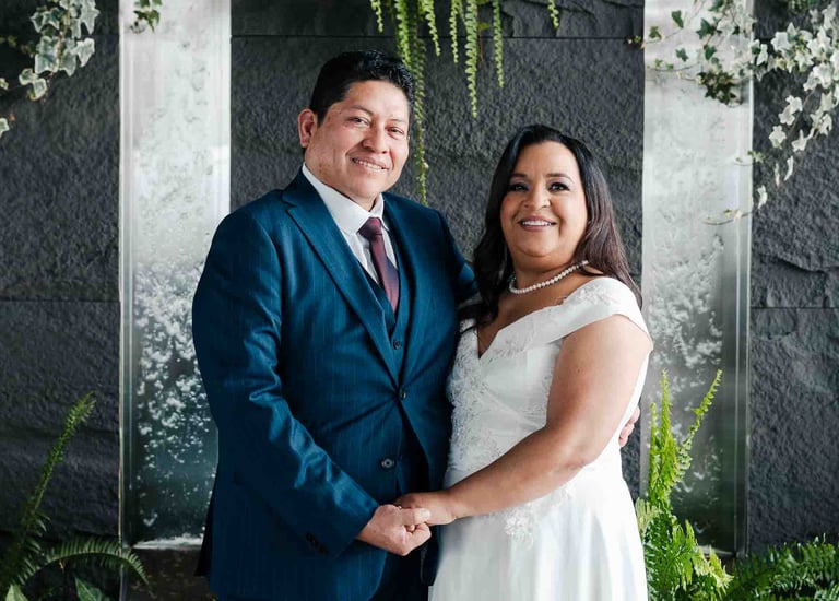 Retrato de bodas de recién casados tomados de la mano en un espacio elegante con plantas y cascadas en Quito Ecuador