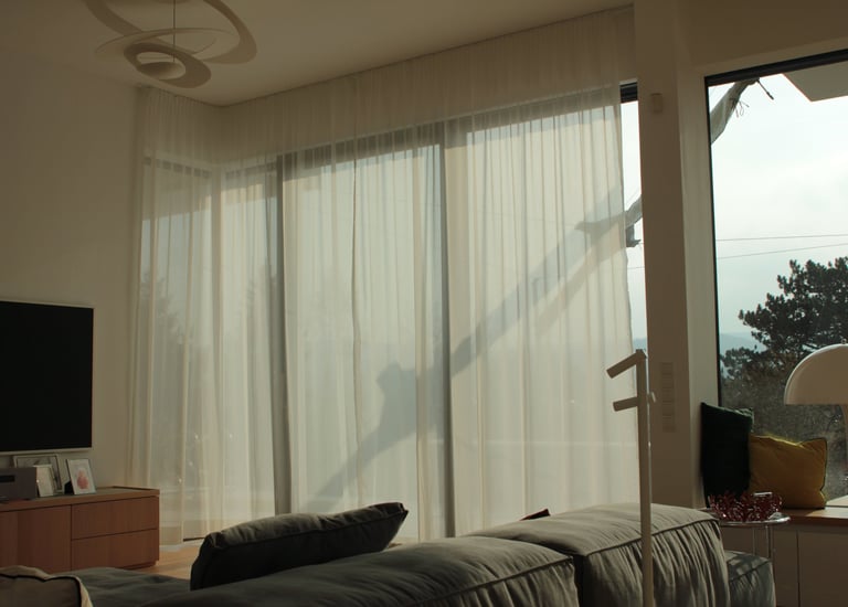 A big window hanged with wavy day curtains