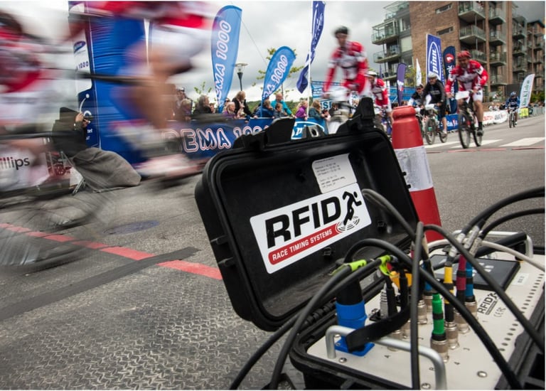 A photo of racers zooming by an RFID chip collection timing station in the midst of a race