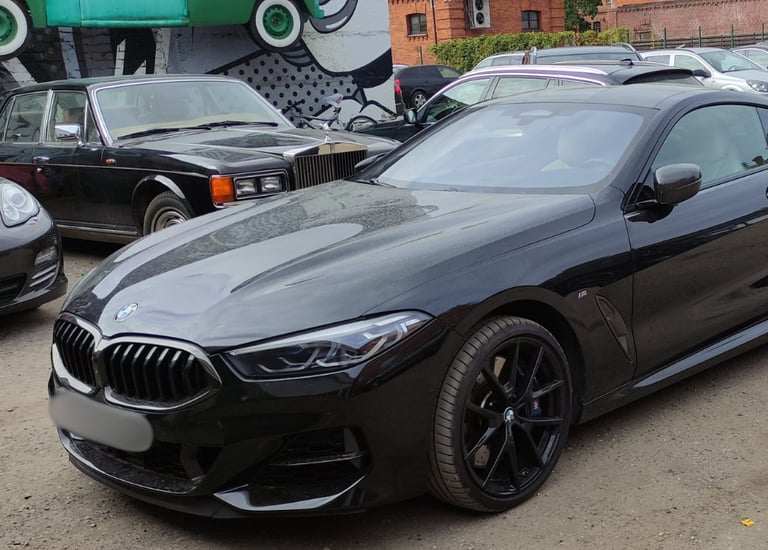 an Enlab black bmw m4 coupe with a black and white car