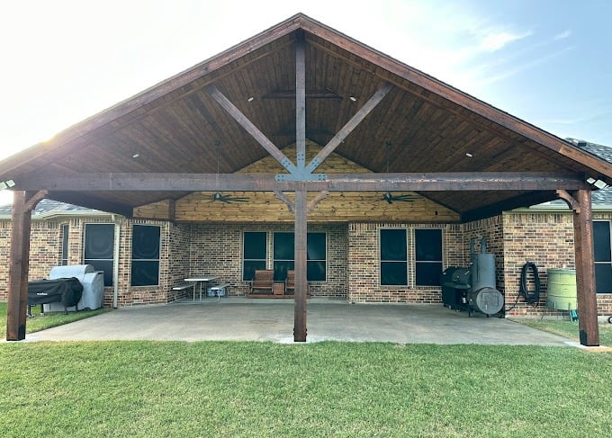 Larged covered patio with a vaulted wooden ceiling.