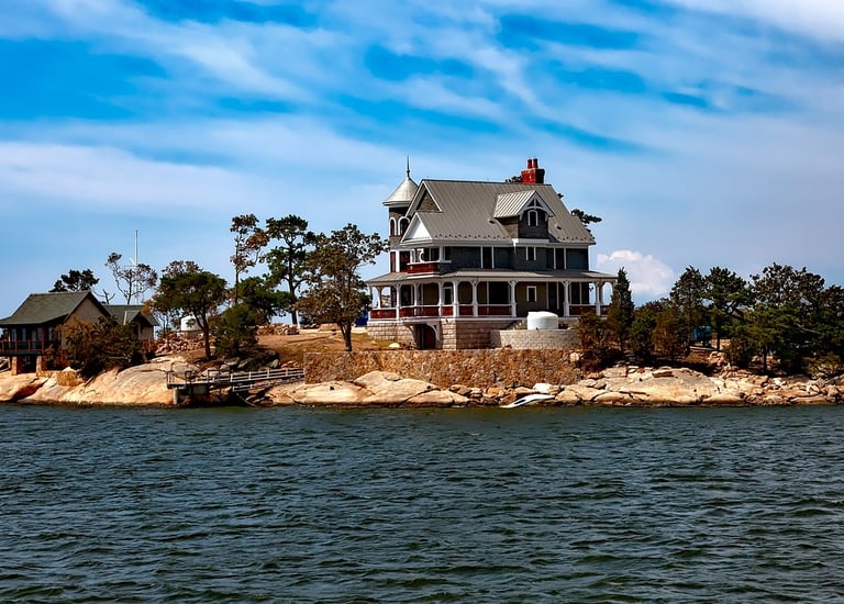 a house on a small island with a boat in the water