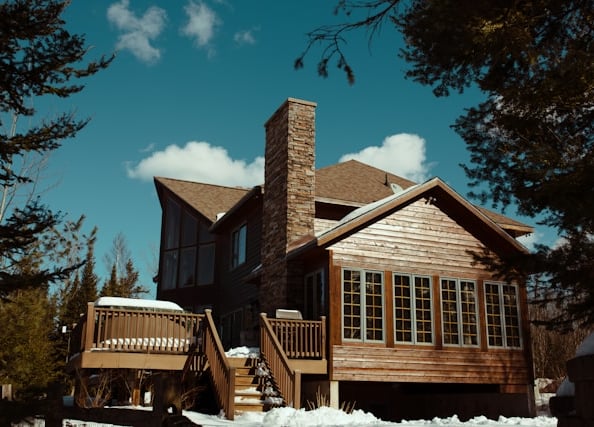 a house with a wooden deck and tall chimney