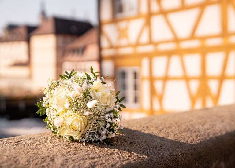 a bouquet of white flowers on a stone wall