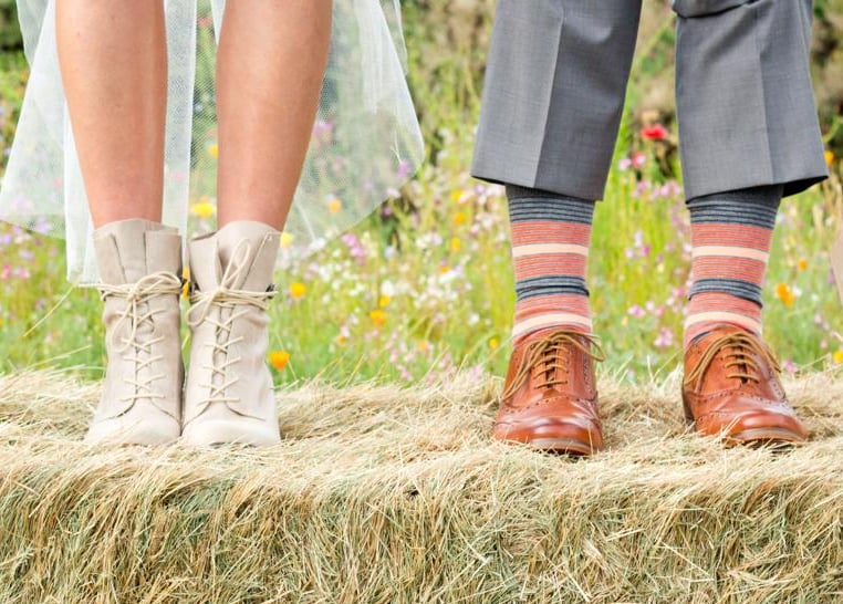 the feet of a couple of people standing on hay bale