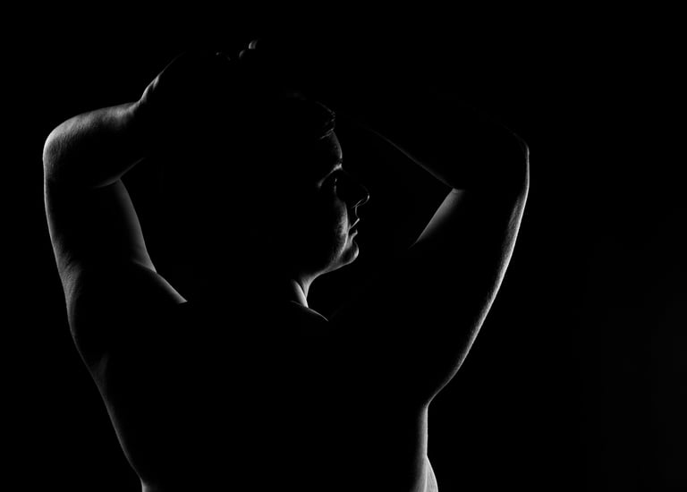 Photo de femme de dos en clair obscur, on ne voit que les contours de la silouhette