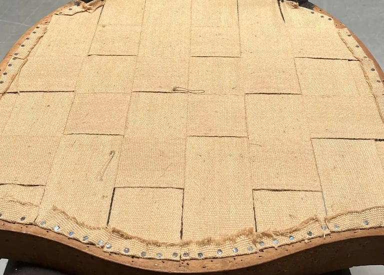 Un fauteuil crapaud à l'envers pour montrer le sangle sur le fond