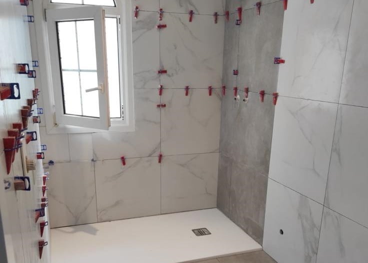 Pose de carrelage blanc brillant dans salle de bain contemporaine