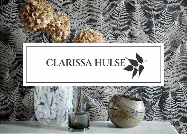 Clarissa Hulse fern wallpaper behind a marble mantel with dried hydrangeas and decorative glass vases.
