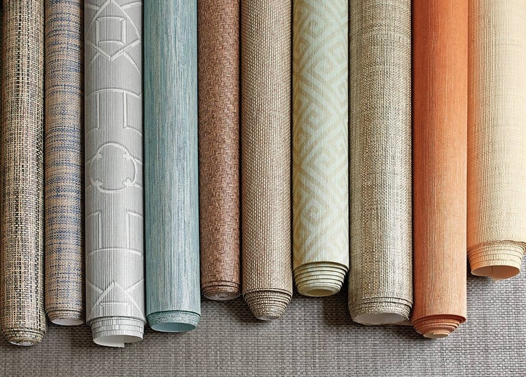 Textured wallpaper rolls in various colors and patterns for modern interior design and home decor.