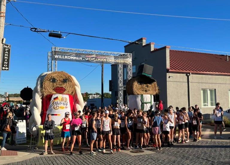 A photo of runners lined up for the start of the Cullman Oktoberfest with a bavarian backdrop