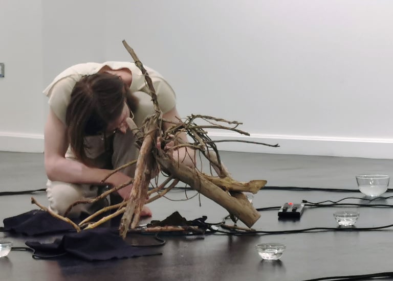 performance artist with wooden sculpture