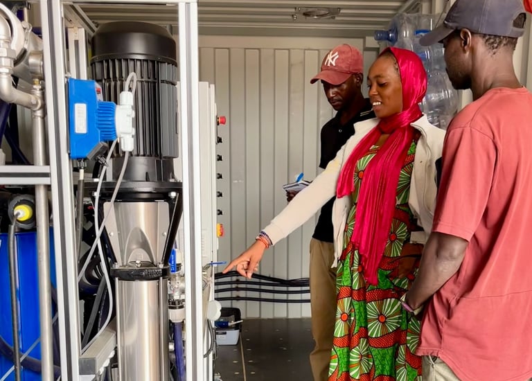 ein Mann und eine Frau stehen in einem Container vor einer Wasserproduktion