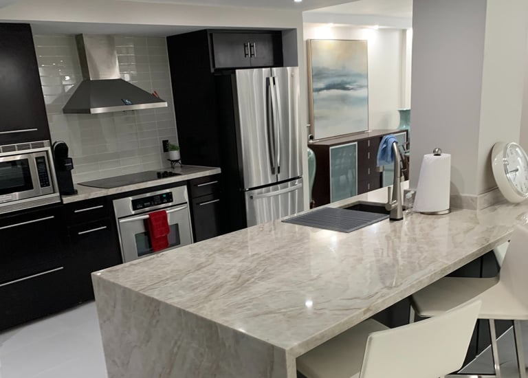 a kitchen with a marble counter top and chairs