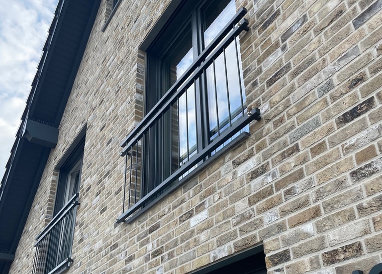 Individuell gefertigtes Fenstergeländer aus pulverbeschichtetem Stahl am Haus