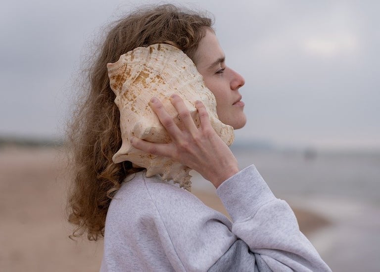 a woman in a gray sweater and a shell shell