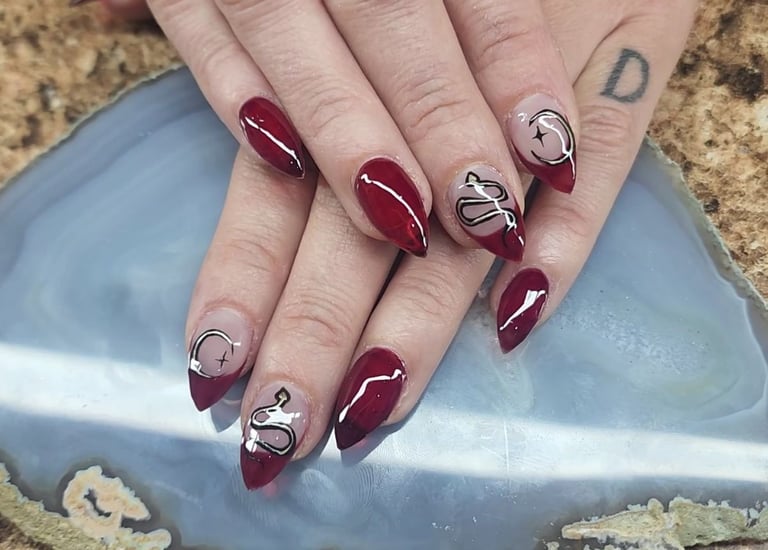 Red custom acrylic nail art with snakes and stiletto tips tips