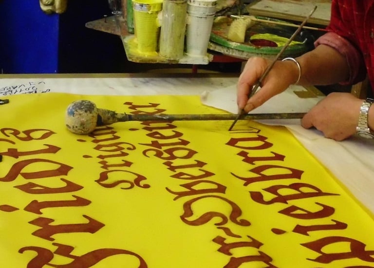 a woman is cutting a banner board with a knife
