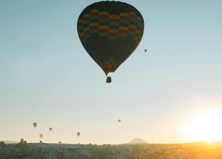 mehrere Heißluftballons am Himmel mit Sonnenuntergang