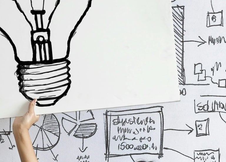 a woman holding up a sign with a picture of a light bulb bulb