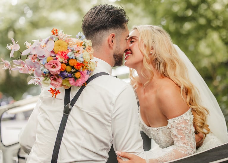 Brautpaar küsst sich im Auto
