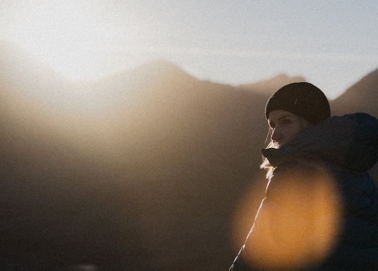 a photo of sunny winetr day in the mountains of scotland girl in a hat