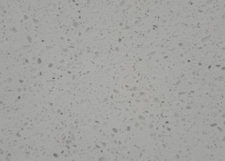 Close-up of light gray quartz slab with speckled texture